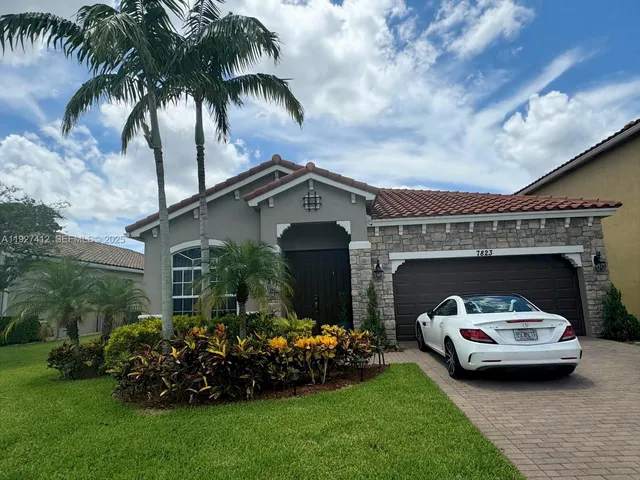 a car parked in front of a house with a garden