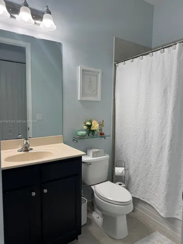 a bathroom with a sink a toilet and shower curtain
