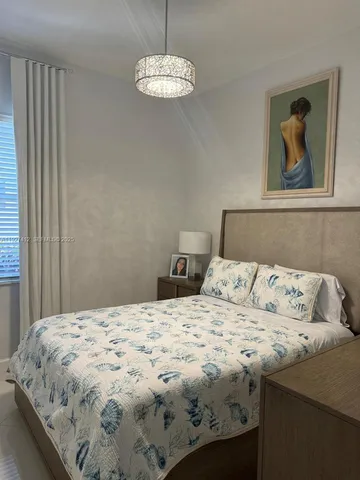 a bedroom with a bed and a chandelier