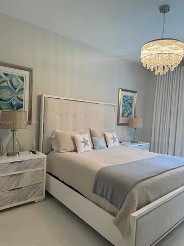 a bedroom with a bed and a chandelier