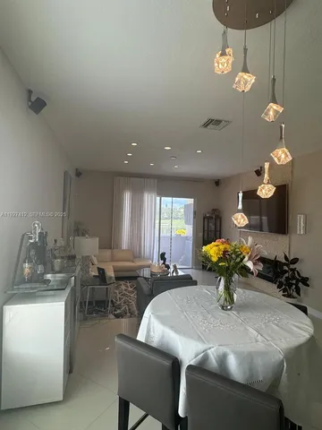 a kitchen with a dining table chairs sink and dishwasher
