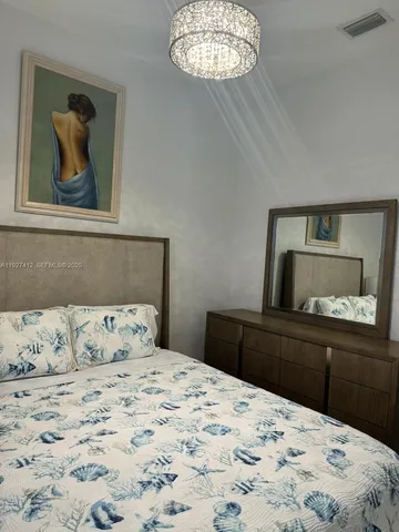 a bedroom with a bed and a chandelier