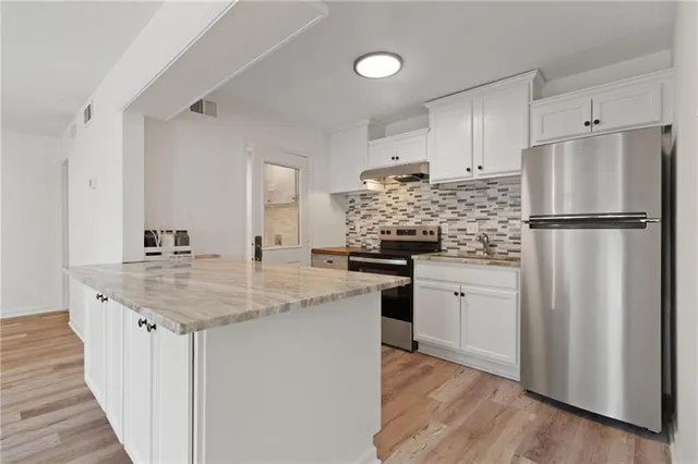 a kitchen with appliances a sink and a refrigerator