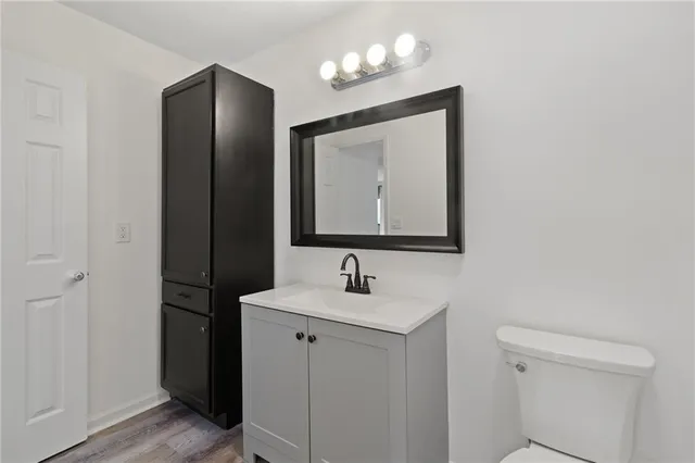 a bathroom with a toilet sink and mirror