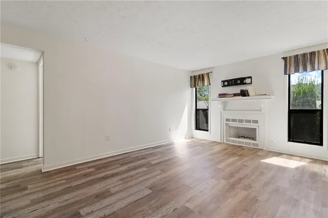 wooden floor fireplace and natural light in room