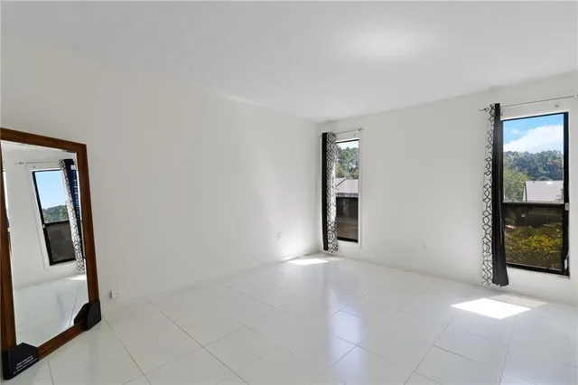 an empty room with windows and closet