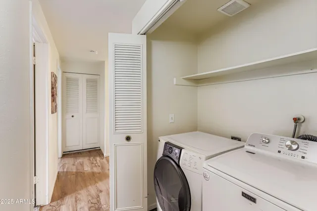 a view of washer and dryer with bathroom in the background
