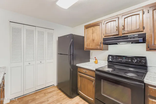 a kitchen with stainless steel appliances granite countertop a refrigerator stove and a sink