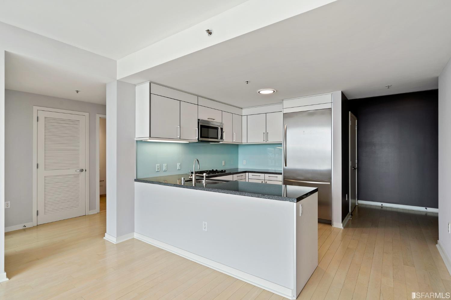 301 Main Street, Unit 17E San Francisco, CA 94105 - Photo 4 of 22 a kitchen with stainless steel appliances granite countertop a sink and a refrigerator