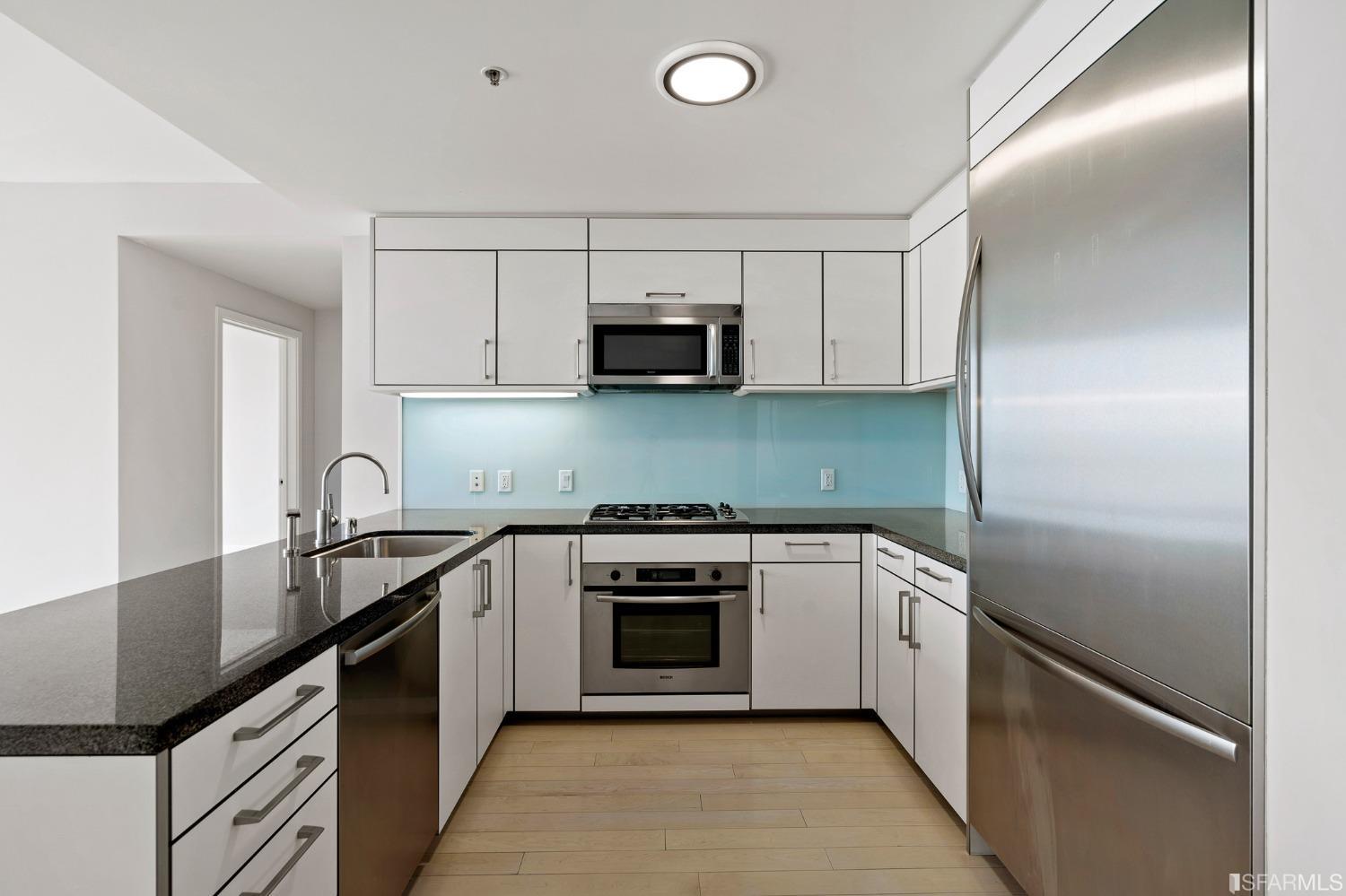 301 Main Street, Unit 17E San Francisco, CA 94105 - Photo 5 of 22 a kitchen with granite countertop a stove sink and cabinets