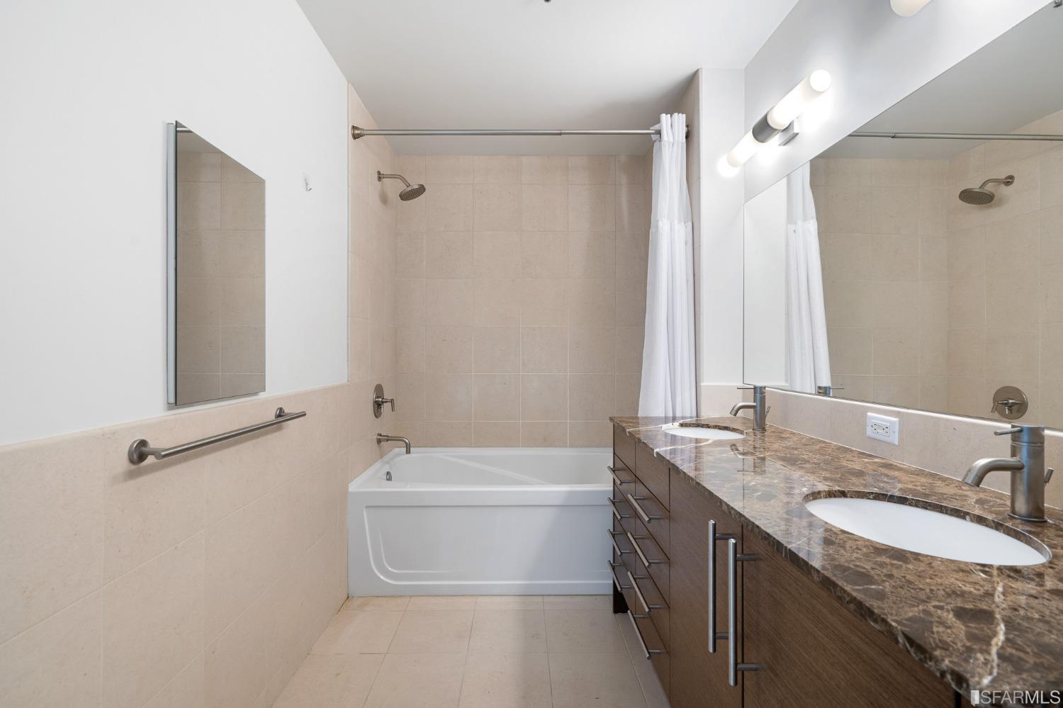 301 Main Street, Unit 17E San Francisco, CA 94105 - Photo 9 of 22 a bathroom with a granite countertop sink and a mirror