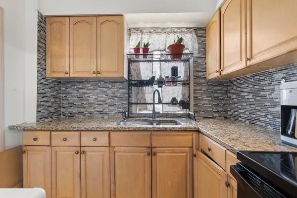 a kitchen with granite countertop a sink and a stove
