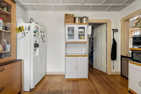 a view of a kitchen with fridge and wooden floor