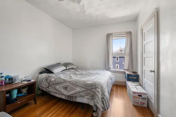 a bedroom with a bed and wooden floor