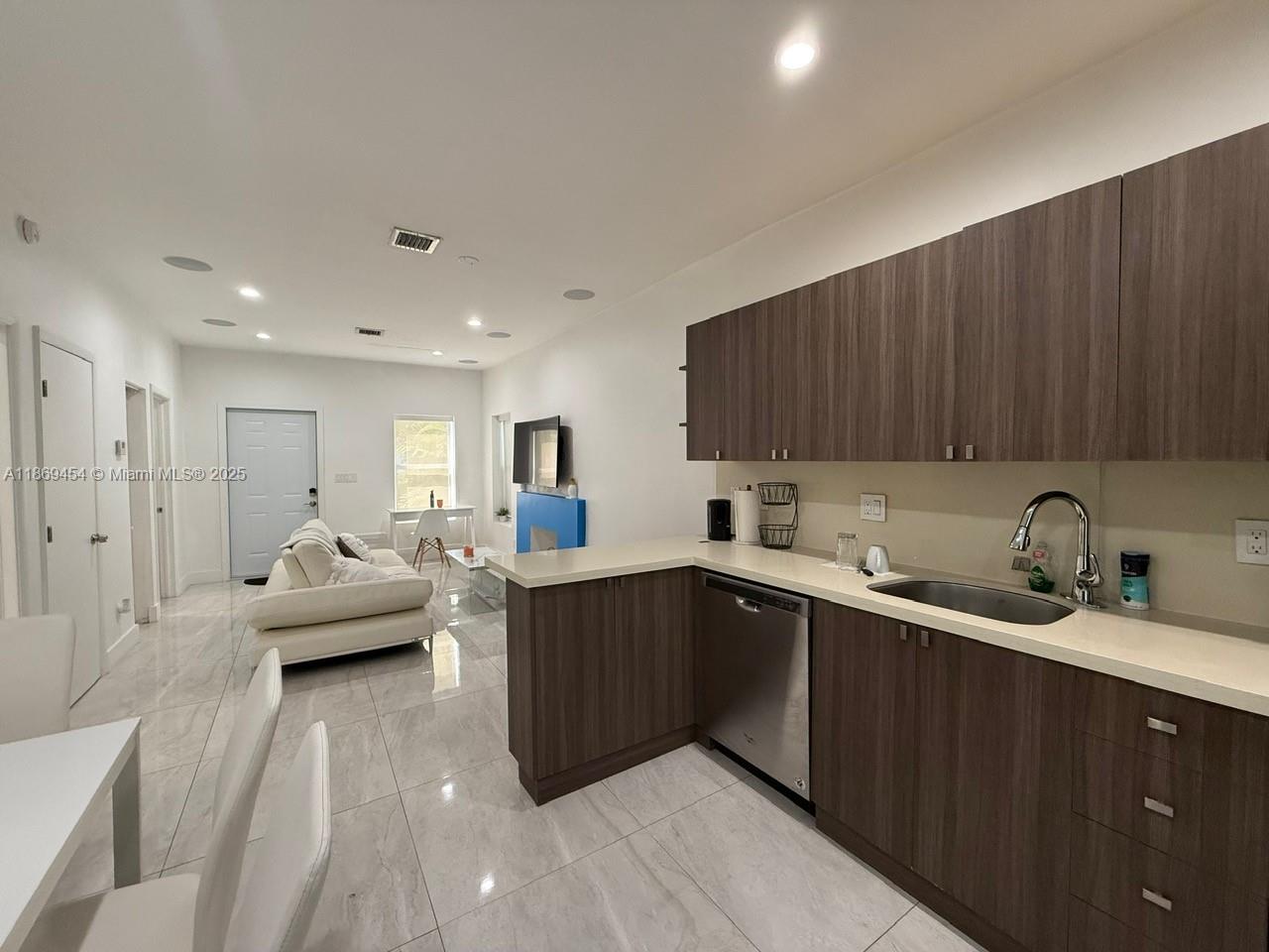 247 Northwest 58th Street Miami, FL 33127 - Photo 13 of 23 a kitchen with sink a refrigerator and cabinets