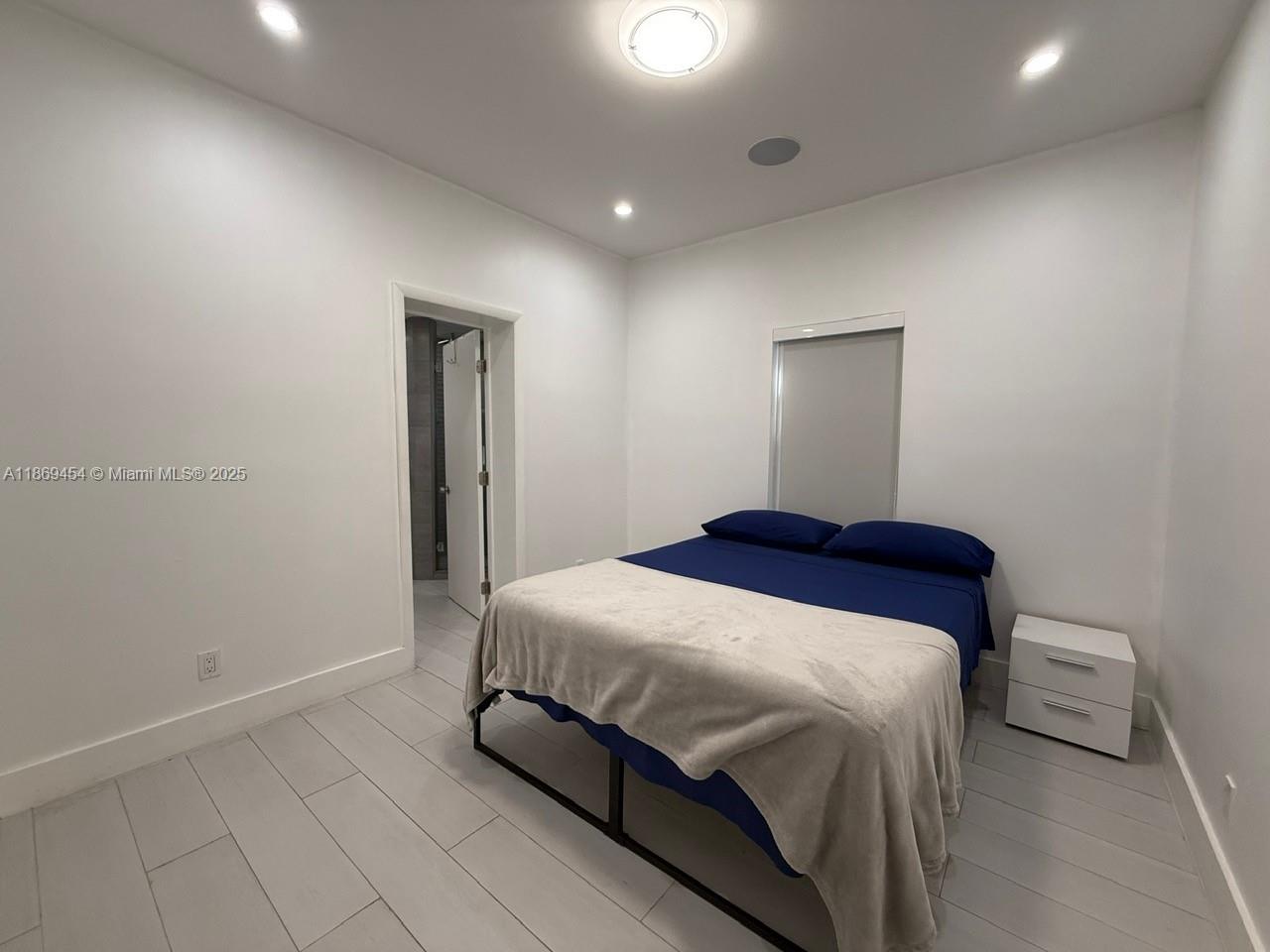 247 Northwest 58th Street Miami, FL 33127 - Photo 14 of 23 a bedroom with a bed and a mirror