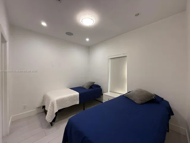 a bedroom with two beds and painting on the wall