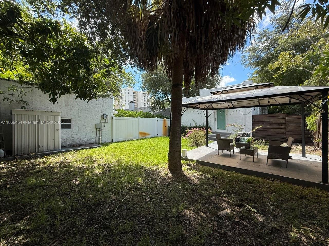247 Northwest 58th Street Miami, FL 33127 - Photo 7 of 23 a view of a backyard with large tree and wooden fence