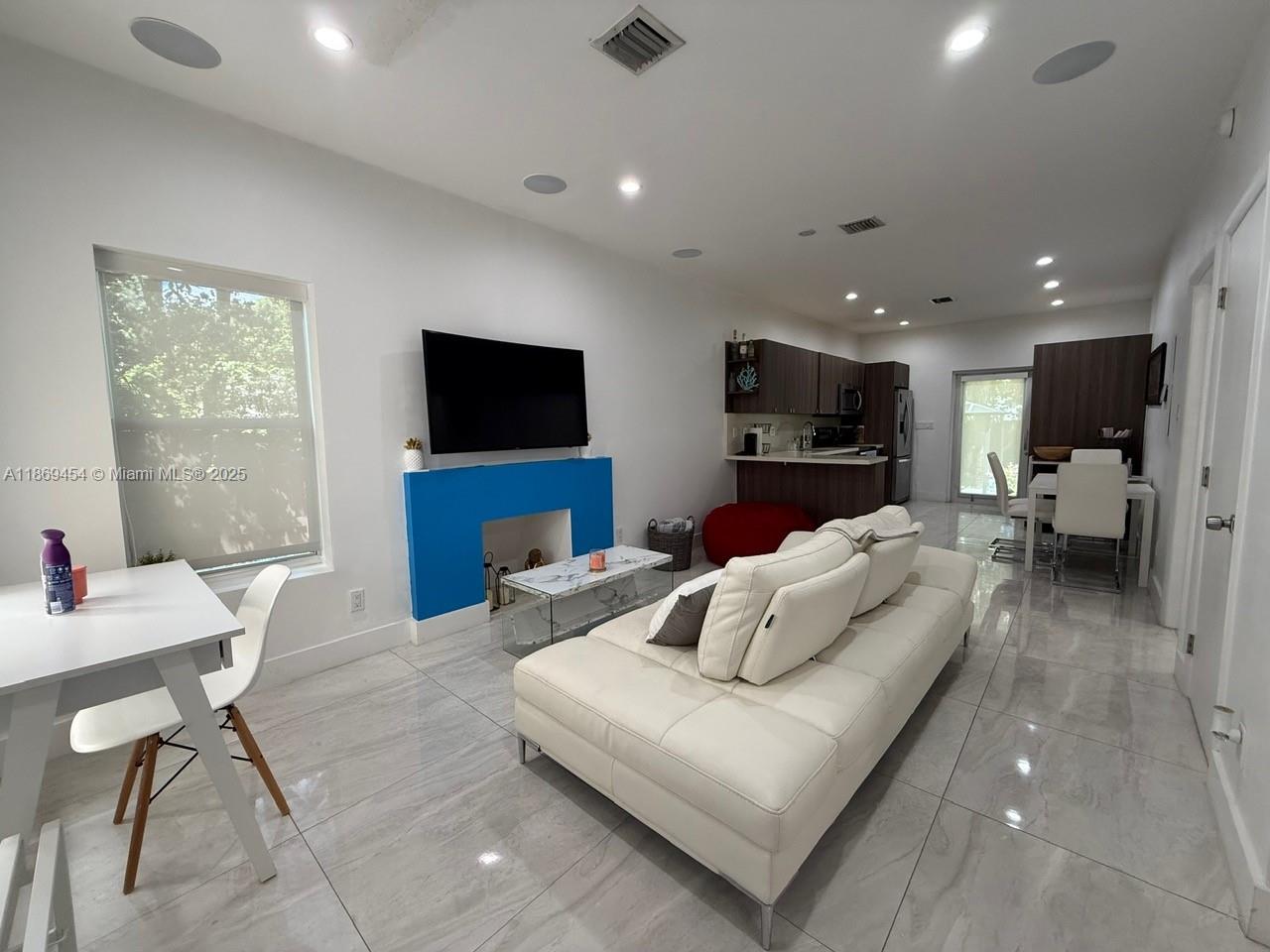 247 Northwest 58th Street Miami, FL 33127 - Photo 8 of 23 a living room with furniture and a flat screen tv