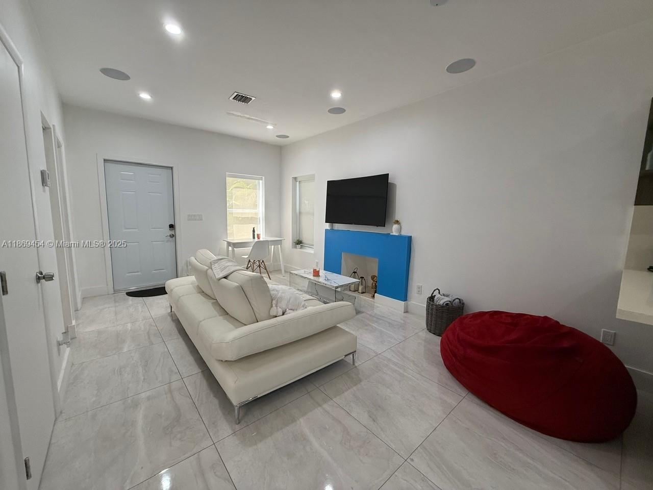 247 Northwest 58th Street Miami, FL 33127 - Photo 9 of 23 a living room with furniture and a flat screen tv