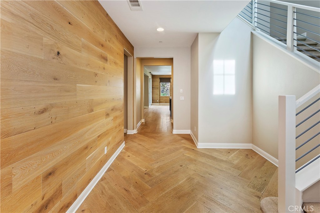 11548 Grimaldi Road Rancho Cucamonga, CA 91701 - Photo 6 of 39 a view of a hallway with wooden floor and a bathroom