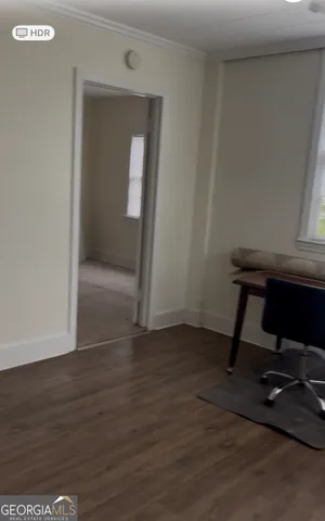 a view of a workspace with wooden floor and a window