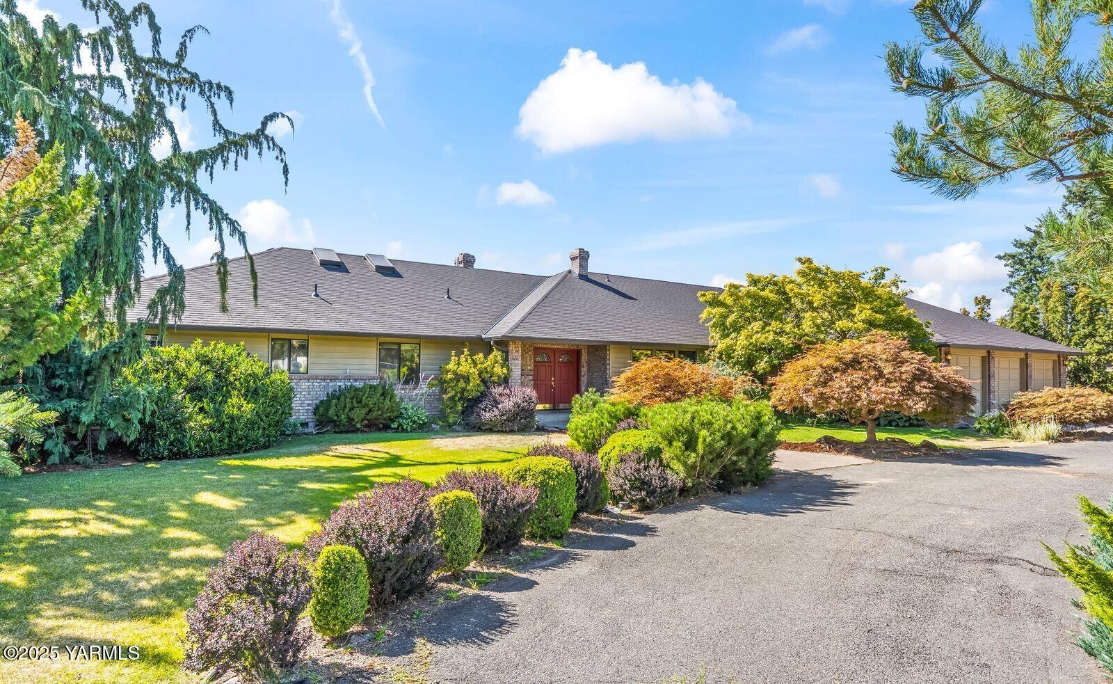 a view of a house with a yard and potted plants