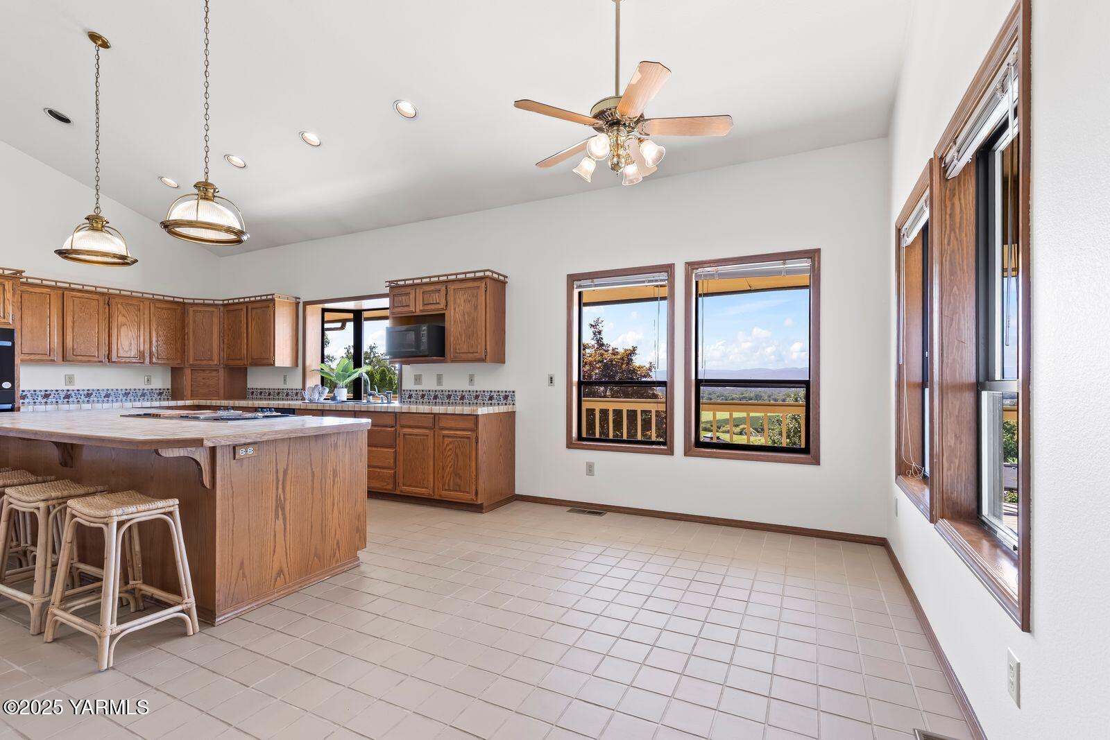 720 Country Club Drive Yakima, WA 98901 - Photo 11 of 48 a large kitchen with kitchen island a large window and stainless steel appliances