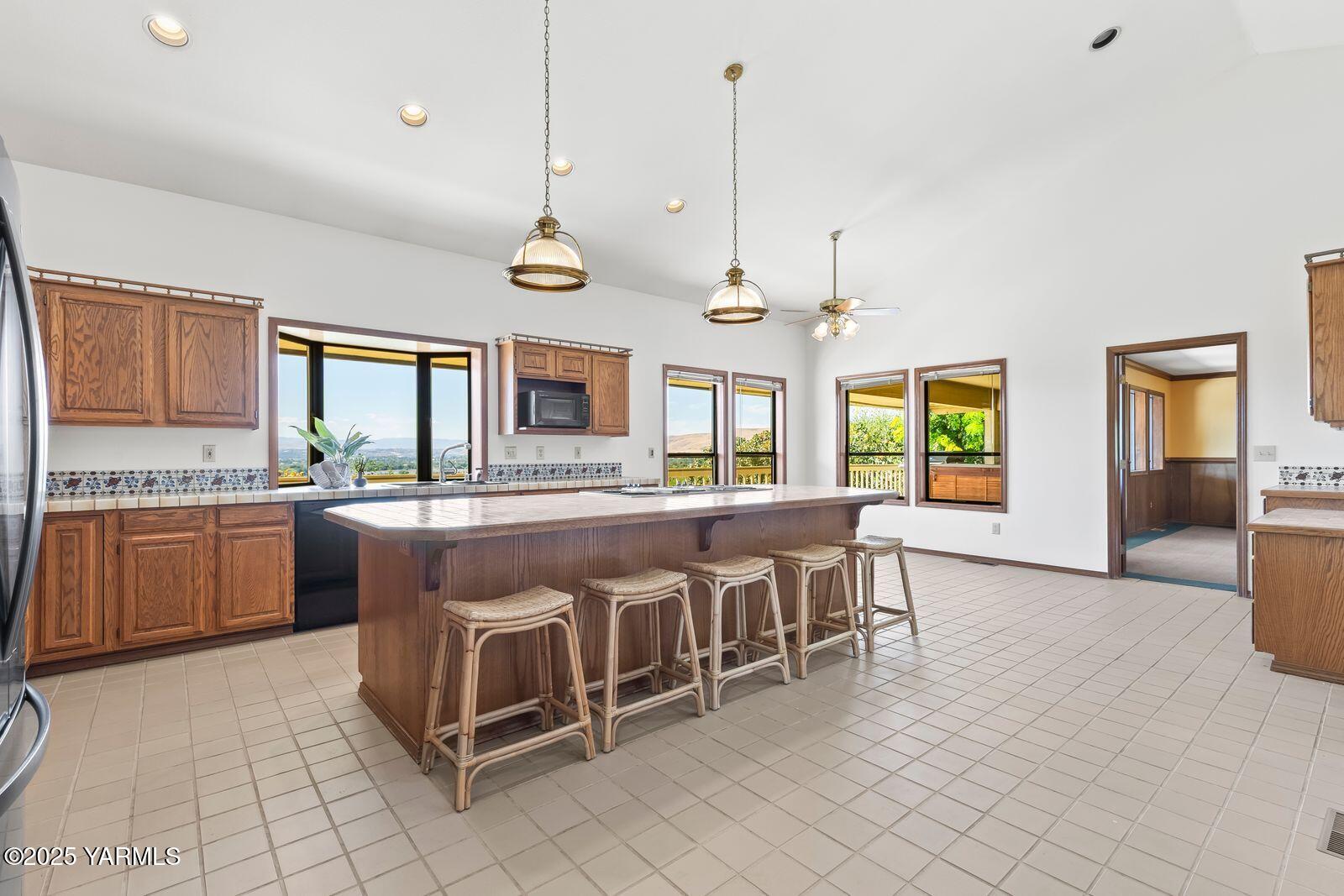 720 Country Club Drive Yakima, WA 98901 - Photo 8 of 48 a large kitchen with kitchen island a large counter space a sink appliances and a counter top space