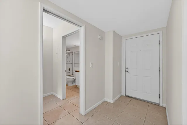 a view of an empty room with closet and a window
