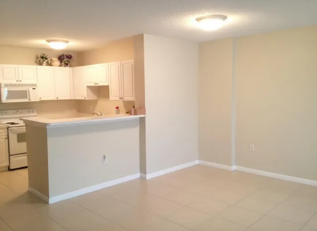 a view of a kitchen with white cabinets
