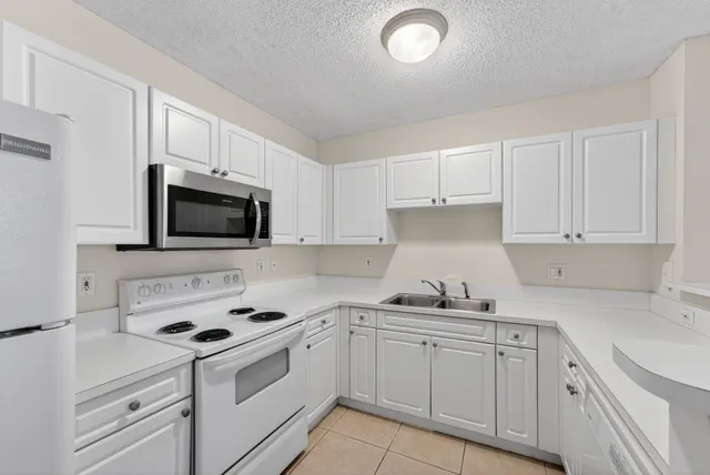 a kitchen with white cabinets and white appliances