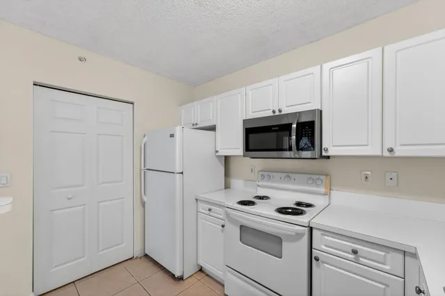 a kitchen with white cabinets and white appliances