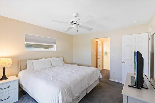 a bedroom with a bed and a flat tv screen on dresser