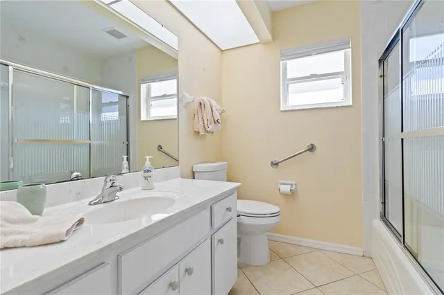 a bathroom with a granite countertop sink a toilet and a mirror