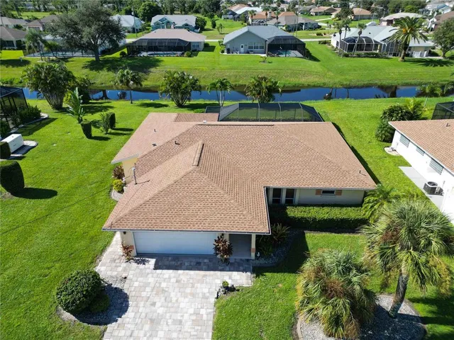 an aerial view of a house with a yard and lake