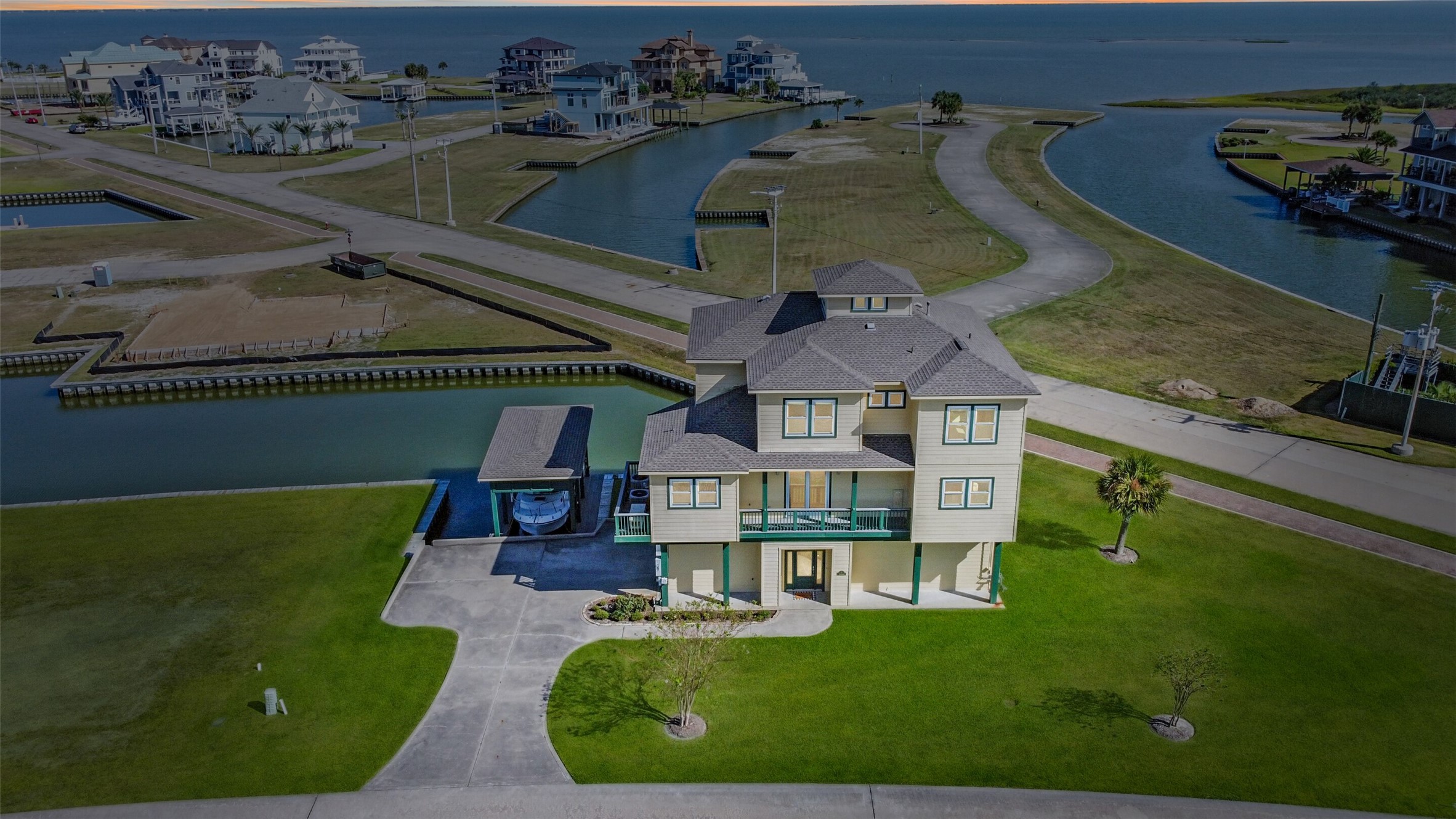 Stunning areal view of this coastal home on canal with boat house and lift.