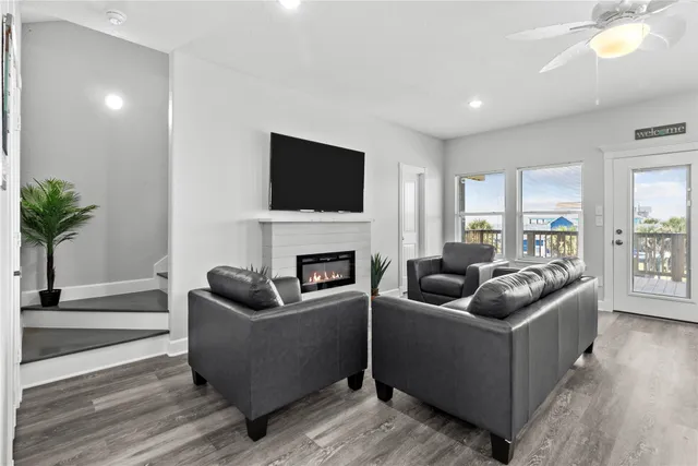 a living room with furniture a flat screen tv and a fireplace