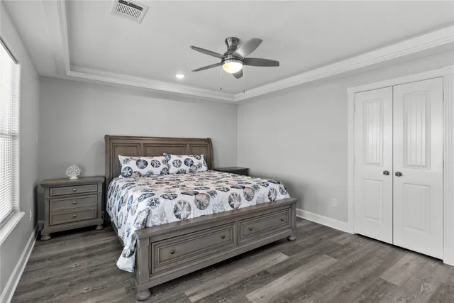 a bed sitting in a bedroom next to a window and a chandelier