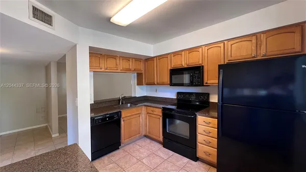 a kitchen with stainless steel appliances granite countertop a stove a refrigerator and a sink