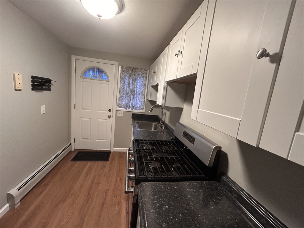 5 Manor Court, Unit 5 Springfield, MA 01118 - Photo 5 of 19 a kitchen with wooden floor a sink and a stove