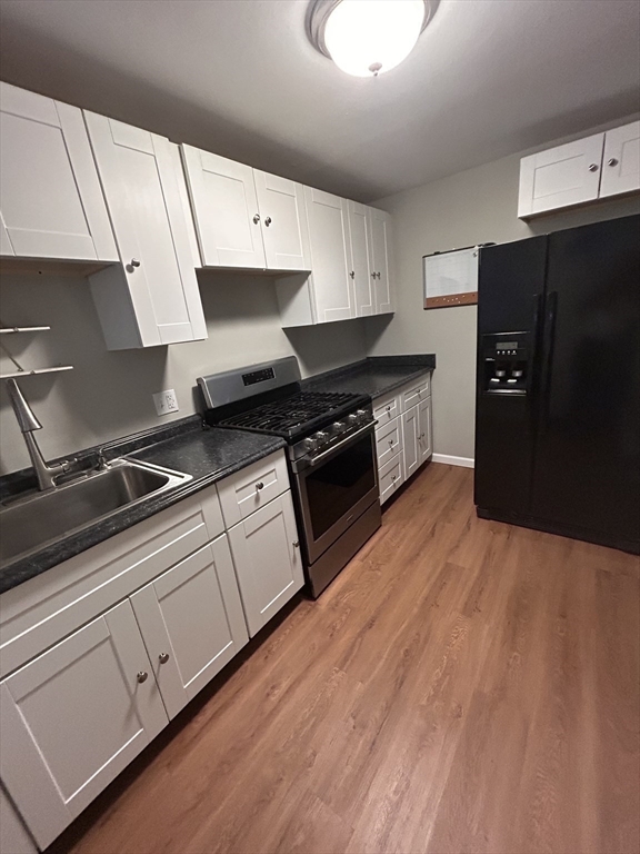 5 Manor Court, Unit 5 Springfield, MA 01118 - Photo 6 of 19 a kitchen with granite countertop a stove and a refrigerator