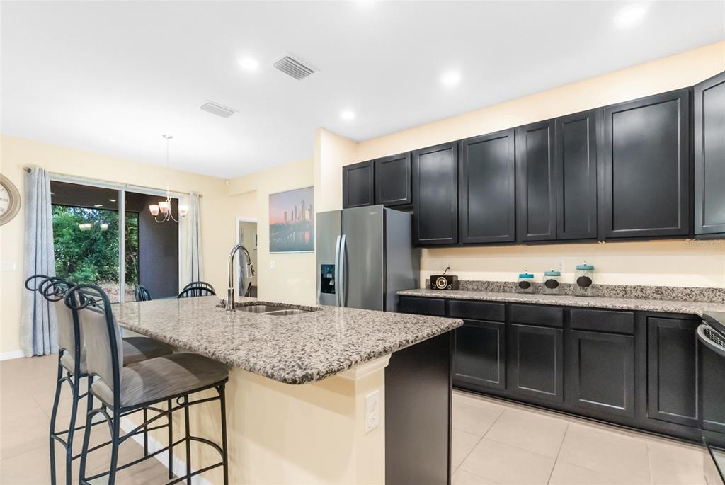 6283 Grapewood Road Spring Hill, FL 34609 - Photo 16 of 41 a kitchen with granite countertop a sink and cabinets