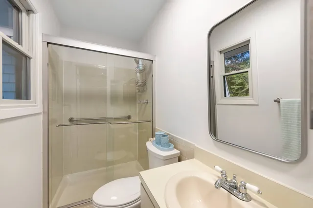 a bathroom with a granite countertop sink toilet and shower