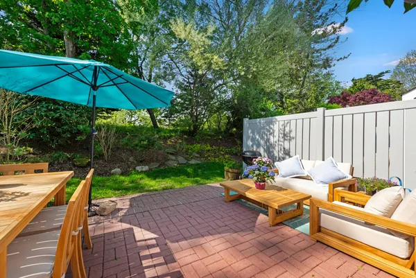 an outdoor sitting area with furniture and umbrella