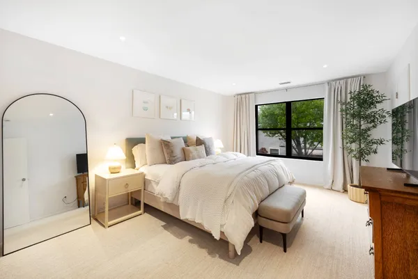 a bedroom with a bed and a large window