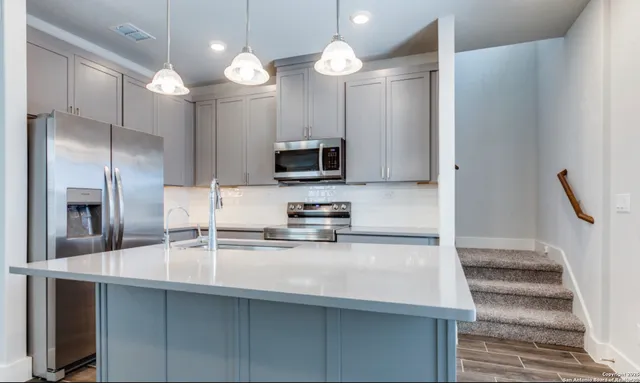 a kitchen with refrigerator a sink and a stove top oven
