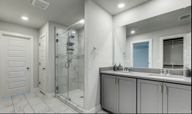 a bathroom with a shower sink and mirror
