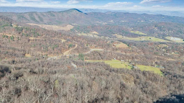 a view of a dry field with mountains in the background