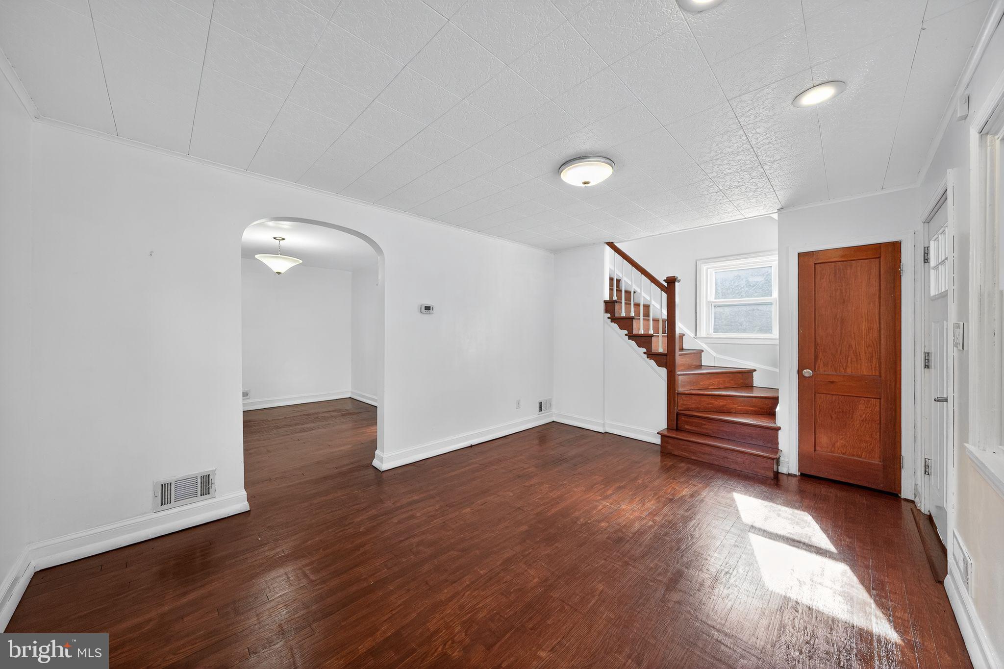 4401 Ridge Drive Baltimore, MD 21229 - Photo 12 of 30 an empty room with wooden floor and stairs